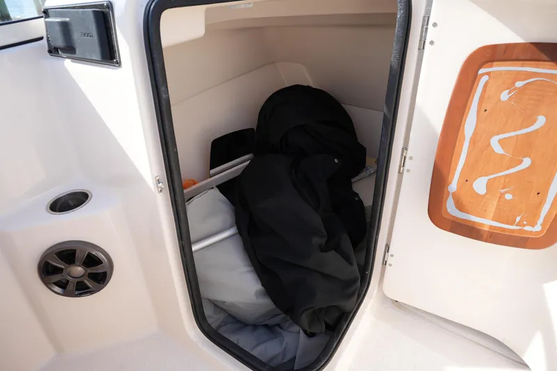 Slide: The Image of Storage compartment in a 2021 Grady-White Freedom 215 boat, featuring interior items and speaker. - 35