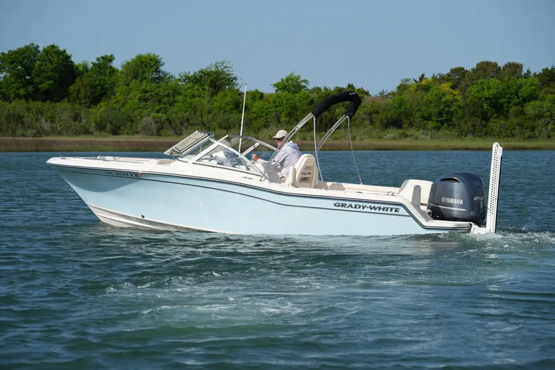 Slide: The Image of 2021 Grady-White Freedom 215 boat cruising on a serene lake. - 8