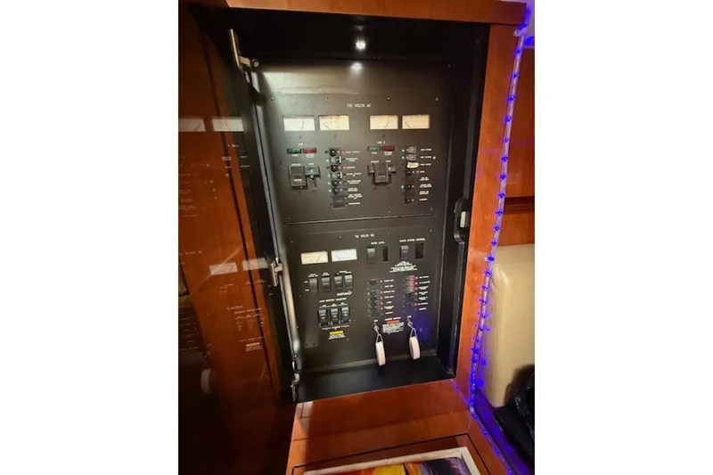 Slide: The Image of Electrical panel inside 2004 Sea Ray 390 Sundancer yacht, featuring various switches and controls. - 16
