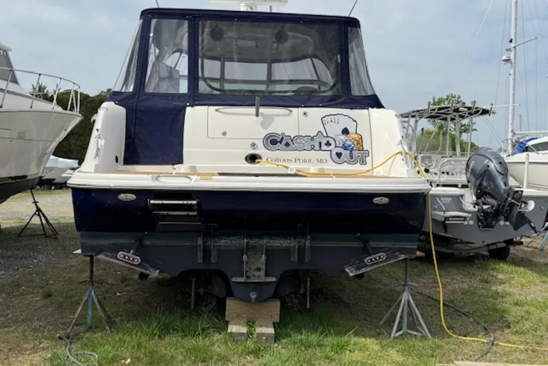 Slide: The Image of 2004 Sea Ray 390 Sundancer yacht on land, rear view, with cover and logo. - 2