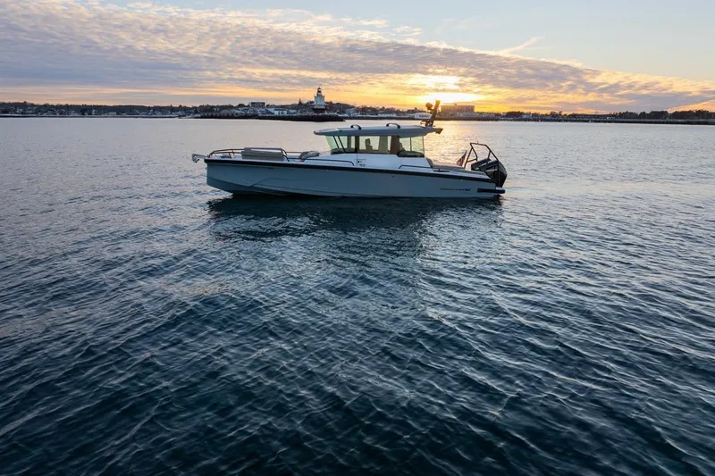 Slide: The Image of 2026 Axopar 29 XC Cross Cabin boat on calm water at sunset. - 1