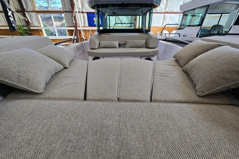 Slide: The Image of 2026 Axopar 29 XC Cross Cabin interior with plush seating and cushions in a boat showroom. - 20