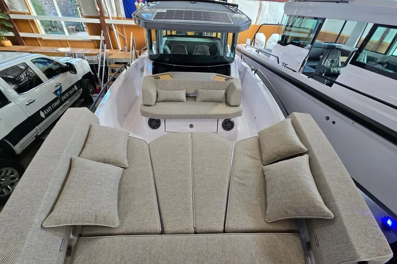 Slide: The Image of 2026 Axopar 29 XC Cross Cabin with spacious seating and modern design in showroom. - 21