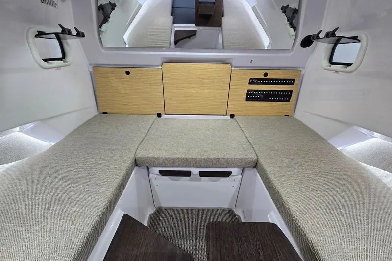 Slide: The Image of 2026 Axopar 29 XC Cross Cabin interior with cushioned seating and wooden cabinetry. - 24
