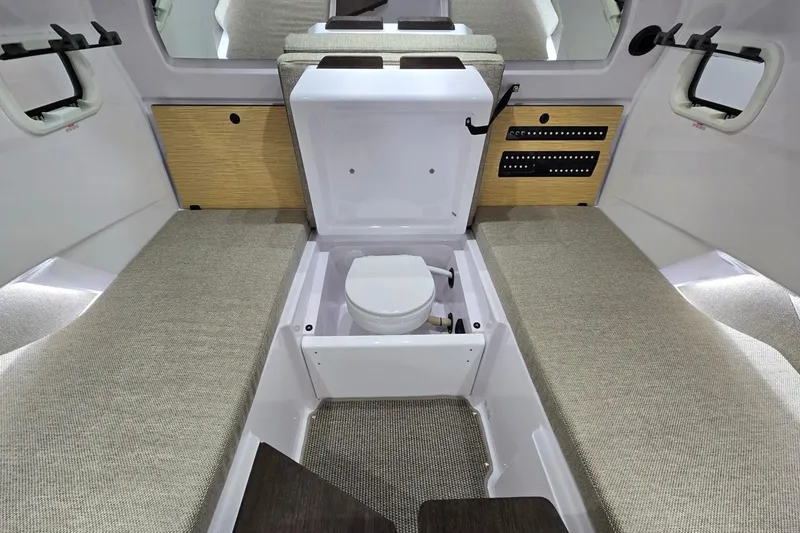Slide: The Image of 2026 Axopar 29 XC Cross Cabin interior with compact toilet and seating area. - 25