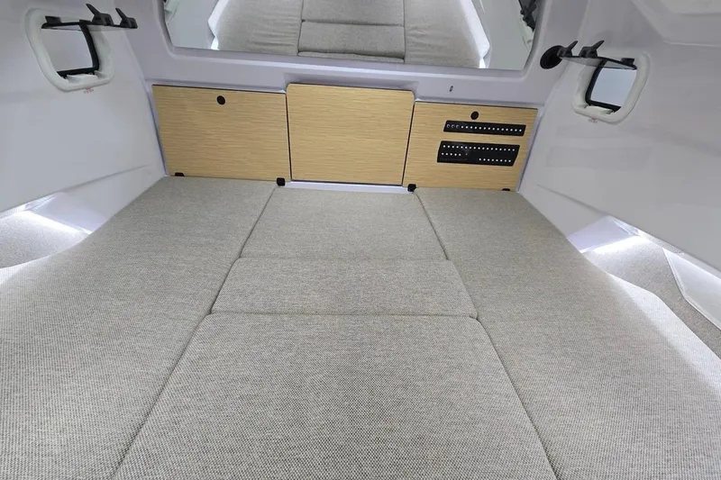 Slide: The Image of 2026 Axopar 29 XC Cross Cabin interior with beige upholstery and wooden cabinetry. - 26
