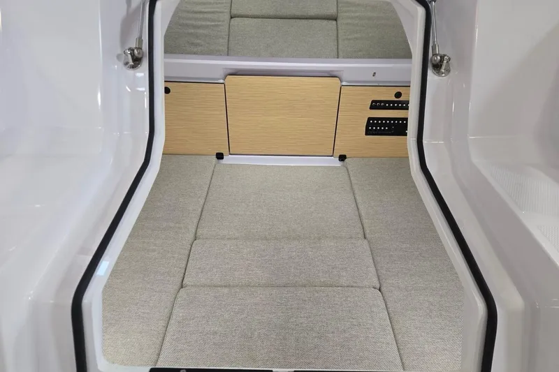 Slide: The Image of 2026 Axopar 29 XC Cross Cabin interior with cushioned seating and wooden paneling. - 27