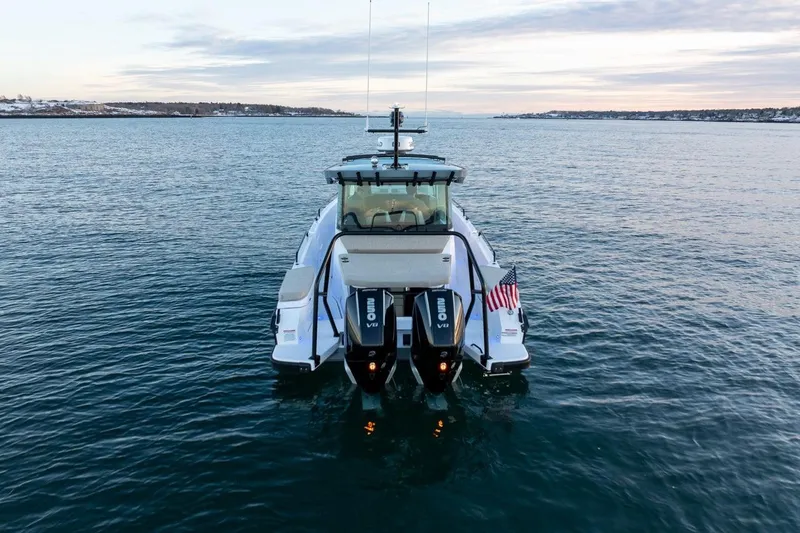Slide: The Image of 2026 Axopar 29 XC Cross Cabin boat on calm water, rear view with dual engines. - 3