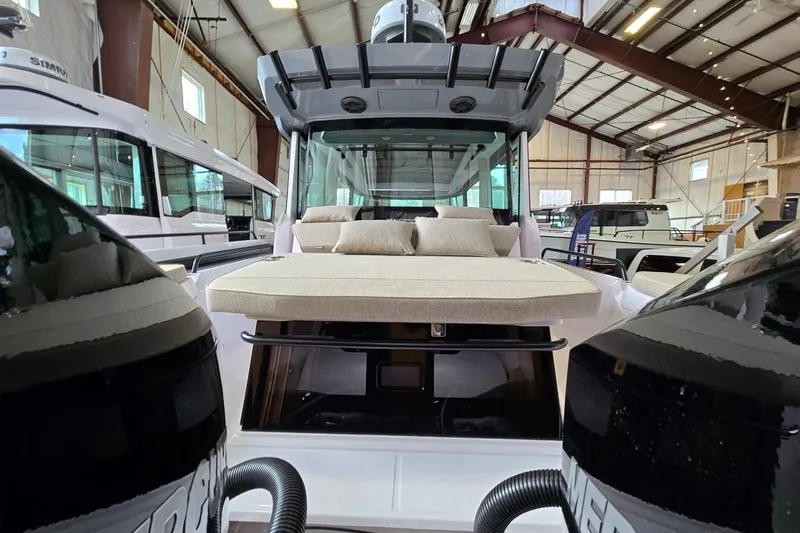 Slide: The Image of 2026 Axopar 29 XC Cross Cabin boat in a showroom, featuring a spacious deck and modern design. - 33