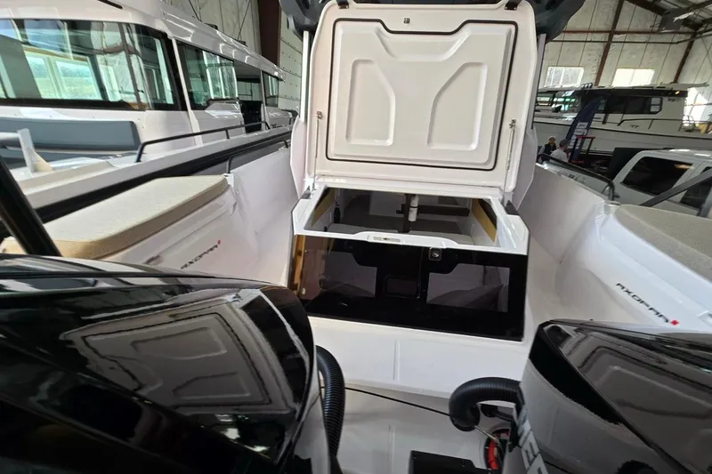 Slide: The Image of 2026 Axopar 29 XC Cross Cabin interior with open storage compartment in a boat showroom. - 38