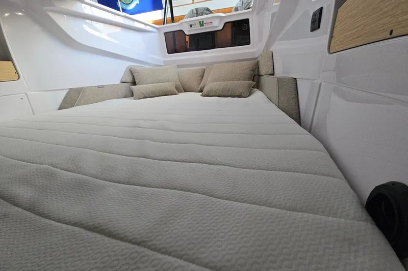 Slide: The Image of 2026 Axopar 29 XC Cross Cabin interior with cozy bed and cushions. - 40