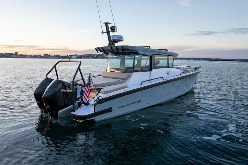 Slide: The Image of 2026 Axopar 29 XC Cross Cabin boat on calm water at sunset. - 5