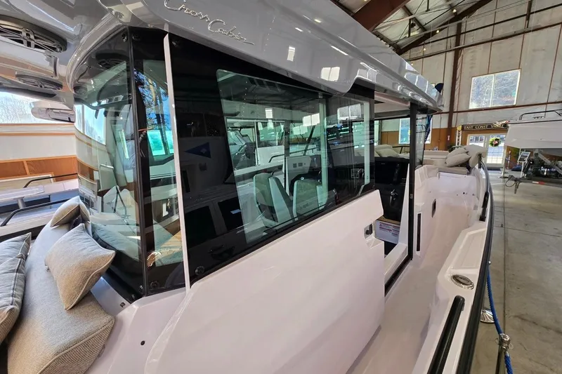 Slide: The Image of 2026 Axopar 29 XC Cross Cabin boat in a showroom, showcasing sleek design and modern features. - 8