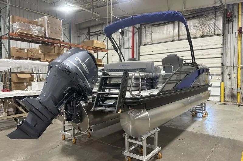 Slide: The Image of 2026 Bennington 23 LXS Swingback pontoon boat with Yamaha engine in a warehouse setting. - 15