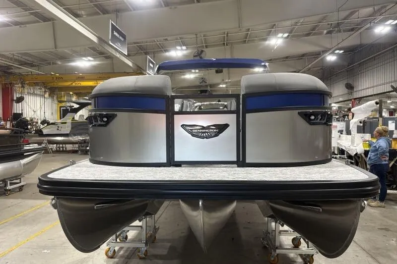 Slide: The Image of 2026 Bennington 23 LXS Swingback pontoon boat in a factory setting. - 2