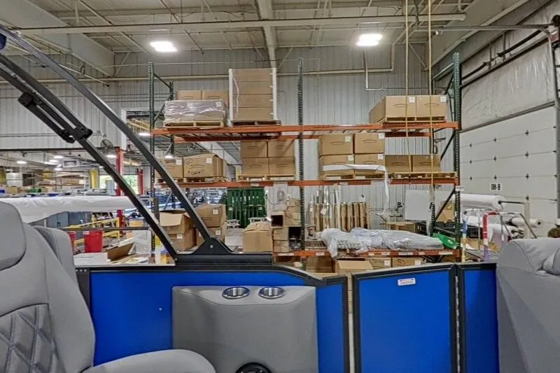 Slide: The Image of Interior view of a 2026 Bennington 23 LXS Swingback in a warehouse setting. - 5