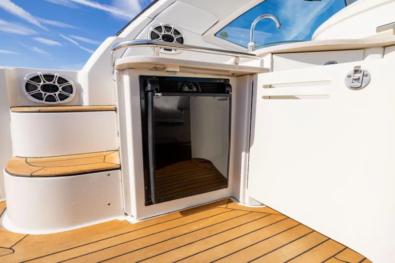 Slide: The Image of Luxury yacht interior with wooden flooring, mini fridge, and sleek design on a 2010 Sea Ray 500 Sundancer. - 24