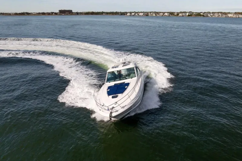Slide: The Image of 2010 Sea Ray 500 Sundancer cruising on open water, creating a dynamic wake. - 3