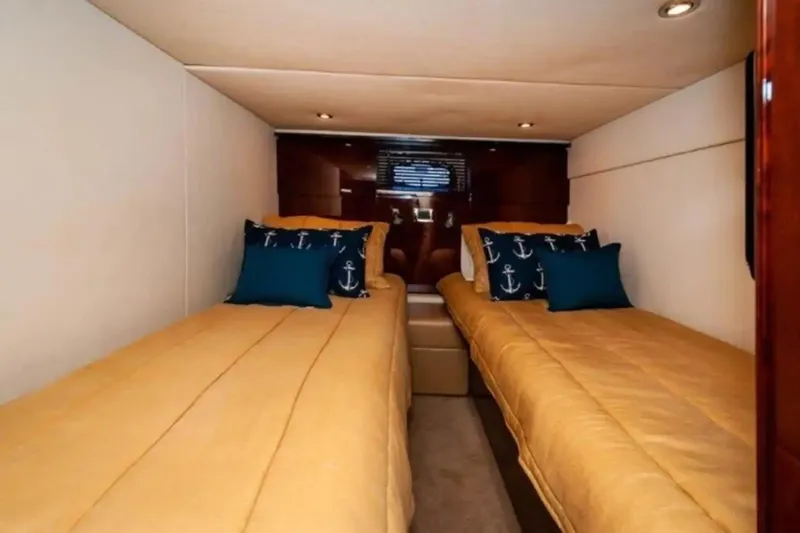 Slide: The Image of Interior cabin of 2010 Sea Ray 500 Sundancer with twin beds and nautical-themed pillows. - 38