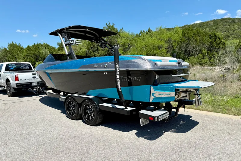 Slide: The Image of 2016 Malibu Wakesetter 25 LSV boat on trailer, parked outdoors on a sunny day. - 12