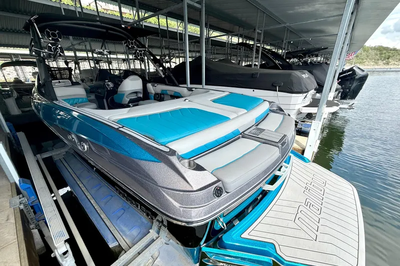 Slide: The Image of 2016 Malibu Wakesetter 25 LSV boat docked, featuring sleek design and vibrant blue accents. - 19