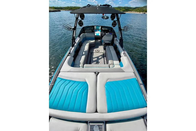 Slide: The Image of 2016 Malibu Wakesetter 25 LSV boat with blue and gray seating on a lake. - 20