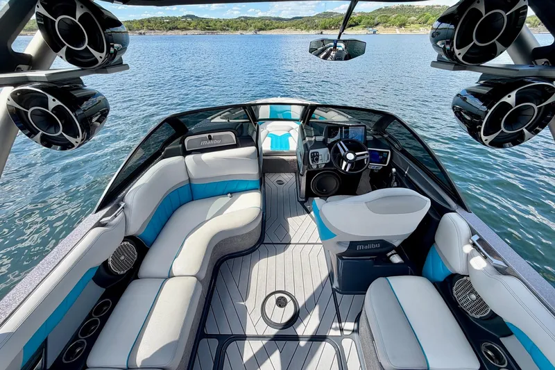 Slide: The Image of 2016 Malibu Wakesetter 25 LSV interior with luxury seating and advanced audio system on a lake. - 26