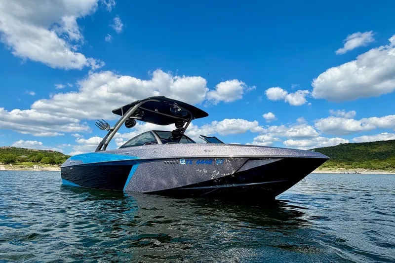 Slide: The Image of 2016 Malibu Wakesetter 25 LSV on a sunny lake, under a vibrant blue sky. - 3