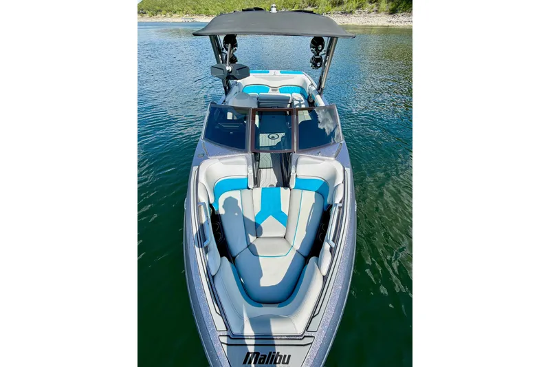 Slide: The Image of 2016 Malibu Wakesetter 25 LSV boat on calm water, featuring sleek design and spacious seating. - 32
