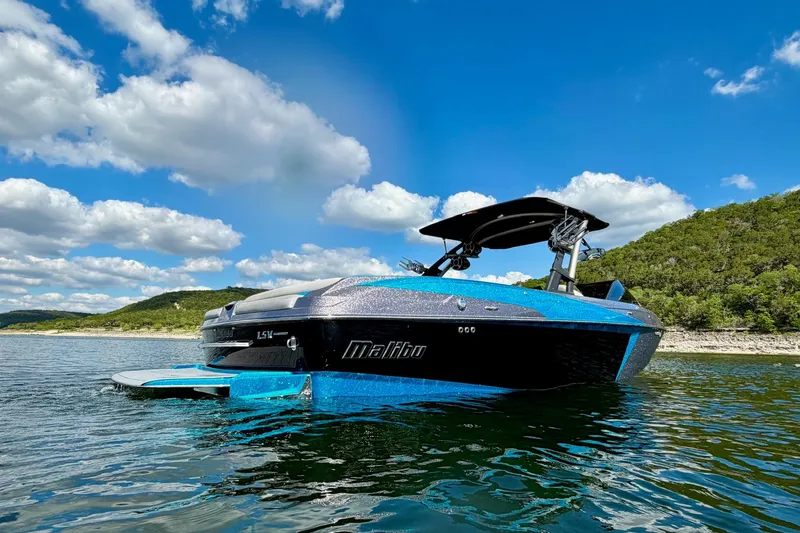 Slide: The Image of 2016 Malibu Wakesetter 25 LSV boat on a scenic lake under a blue sky. - 4