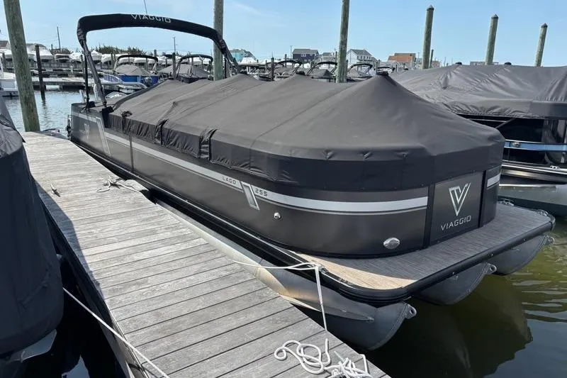 The Image of 2023 Viaggio LAGO 25S pontoon boat docked with cover in marina. - 1
