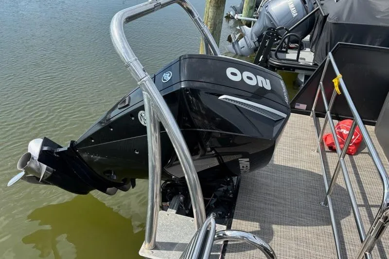 Slide: The Image of 2023 Viaggio LAGO 25S boat with a powerful outboard motor docked by the water. - 6