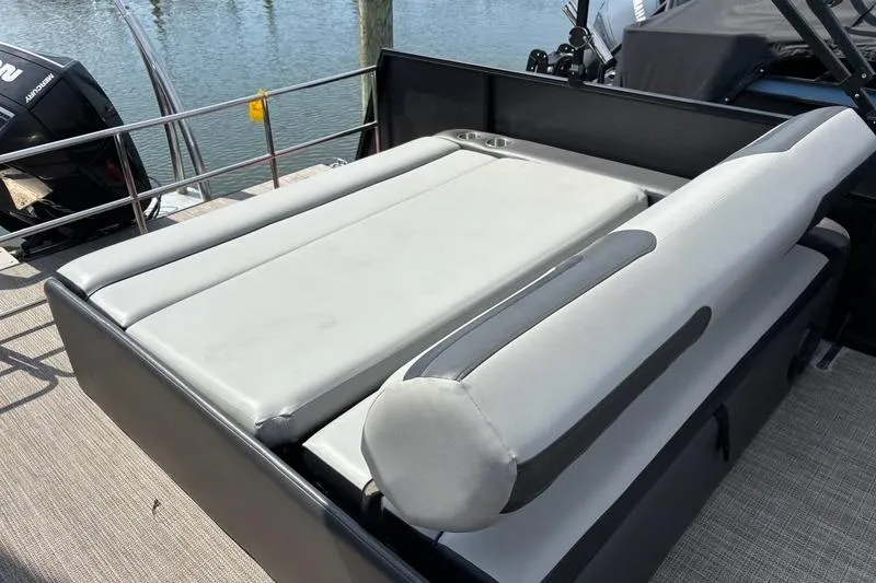 Slide: The Image of 2023 Viaggio LAGO 25S boat with gray seating, docked by the water. - 8