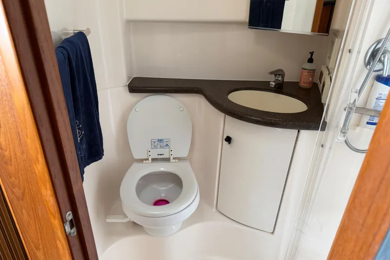 Slide: The Image of Compact bathroom in a 2004 Tiara 3800 yacht with toilet, sink, and mirror. - 21