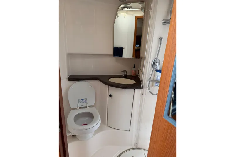 Slide: The Image of Compact bathroom in a 2004 Tiara 3800 yacht with toilet, sink, and shower. - 24