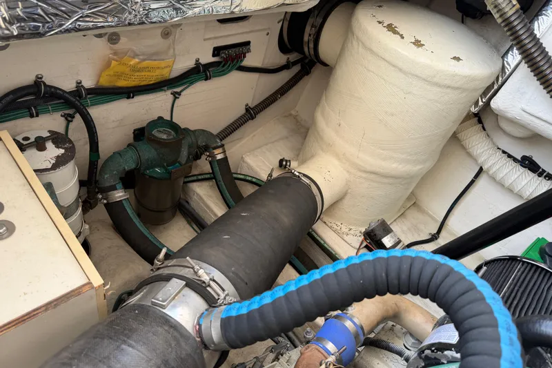 Slide: The Image of Engine compartment of a 2004 Tiara 3800 boat, featuring hoses and mechanical components. - 33