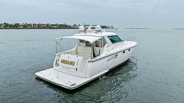 Slide: The Image of 2004 Tiara 3800 yacht interior with white seating and wooden table. - 4