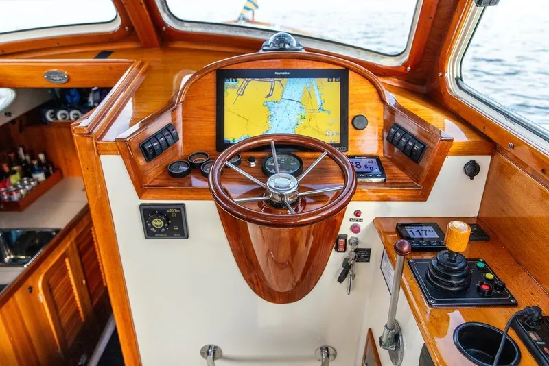Slide: The Image of Helm of 2002 Hinckley Picnic Boat 36 EP with wooden steering wheel and navigation display. - 10