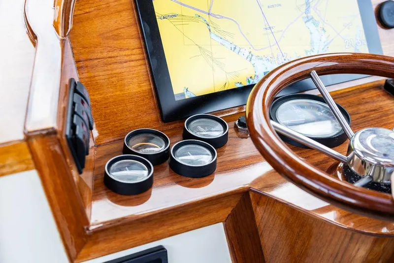 Slide: The Image of Hinckley Picnic Boat 36 EP 2002 dashboard with wooden steering wheel and navigation display. - 11