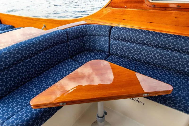 Slide: The Image of Luxurious interior of 2002 Hinckley Picnic Boat 36 EP with blue patterned seating and polished wood table. - 17