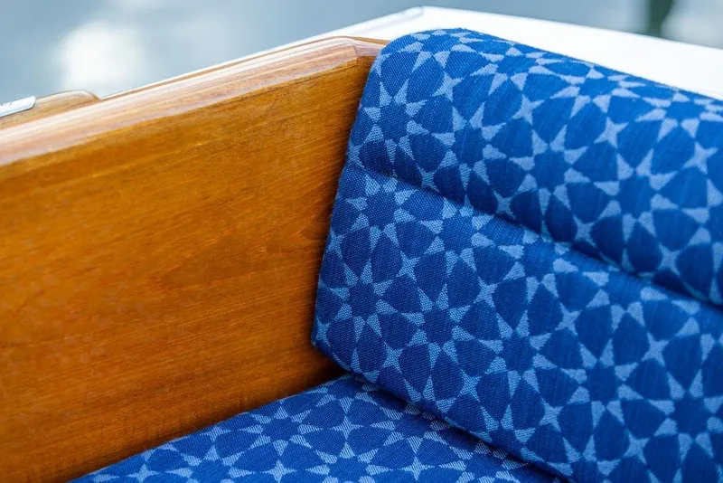 Slide: The Image of Blue patterned upholstery on a wooden seat of a 2002 Hinckley Picnic Boat 36 EP. - 21