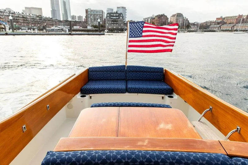 Slide: The Image of Hinckley Picnic Boat 36 EP, 2002, with American flag, city skyline in background. - 22