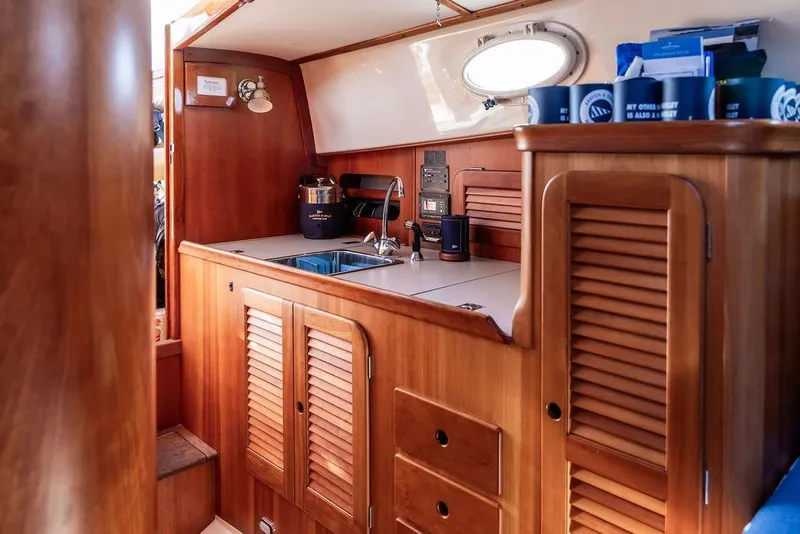 Slide: The Image of Interior of 2002 Hinckley Picnic Boat 36 EP with wooden cabinetry and compact kitchen area. - 29
