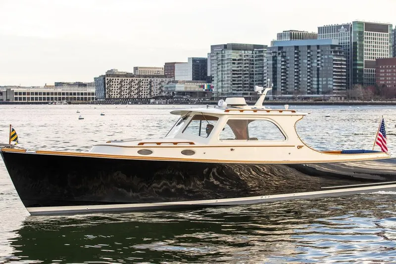 Slide: The Image of 2002 Hinckley Picnic Boat 36 EP cruising near urban waterfront skyline. - 3