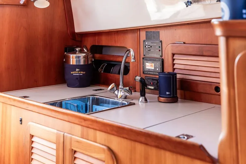 Slide: The Image of 2002 Hinckley Picnic Boat 36 EP interior with wooden cabinetry and modern kitchen amenities. - 30