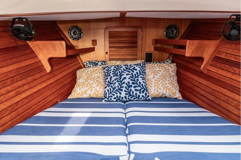 Slide: The Image of Cozy cabin interior of 2002 Hinckley Picnic Boat 36 EP with striped bedding and decorative pillows. - 33