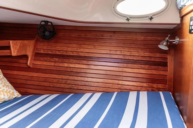 Slide: The Image of Cozy cabin interior of 2002 Hinckley Picnic Boat 36 EP with striped bedding. - 34