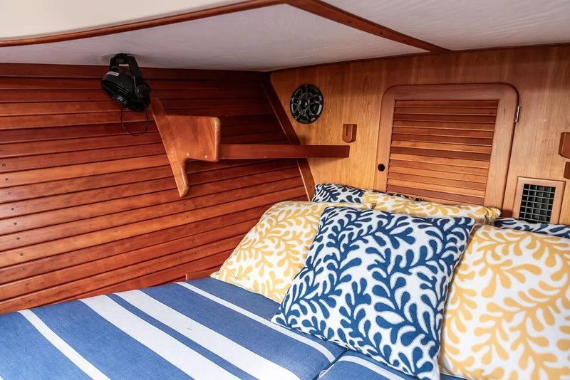 Slide: The Image of Cozy cabin interior of 2002 Hinckley Picnic Boat 36 EP with colorful pillows and wooden paneling. - 35