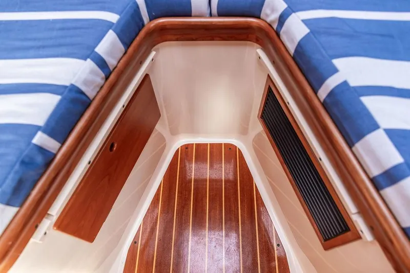 Slide: The Image of Interior view of 2002 Hinckley Picnic Boat 36 EP with striped cushions and wooden flooring. - 37