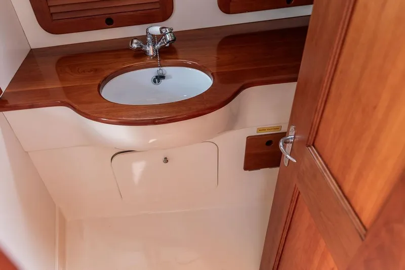 Slide: The Image of Wooden vanity with sink in 2002 Hinckley Picnic Boat 36 EP bathroom. - 38